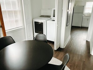 Une cuisine compacte équipée d’un lave-linge, d’un réfrigérateur et d’un évier.