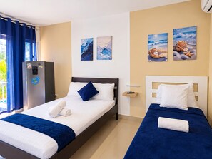 A hotel room with two beds, a minibar, and artwork on the walls. - Sol Caribe apartahotel Punta Cana  (Punta Cana)