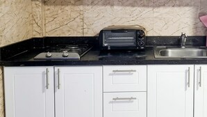 Eine Küche mit schwarzer Arbeitsplatte, einem Toastofen, einem Spülbecken und weißen Schränken.