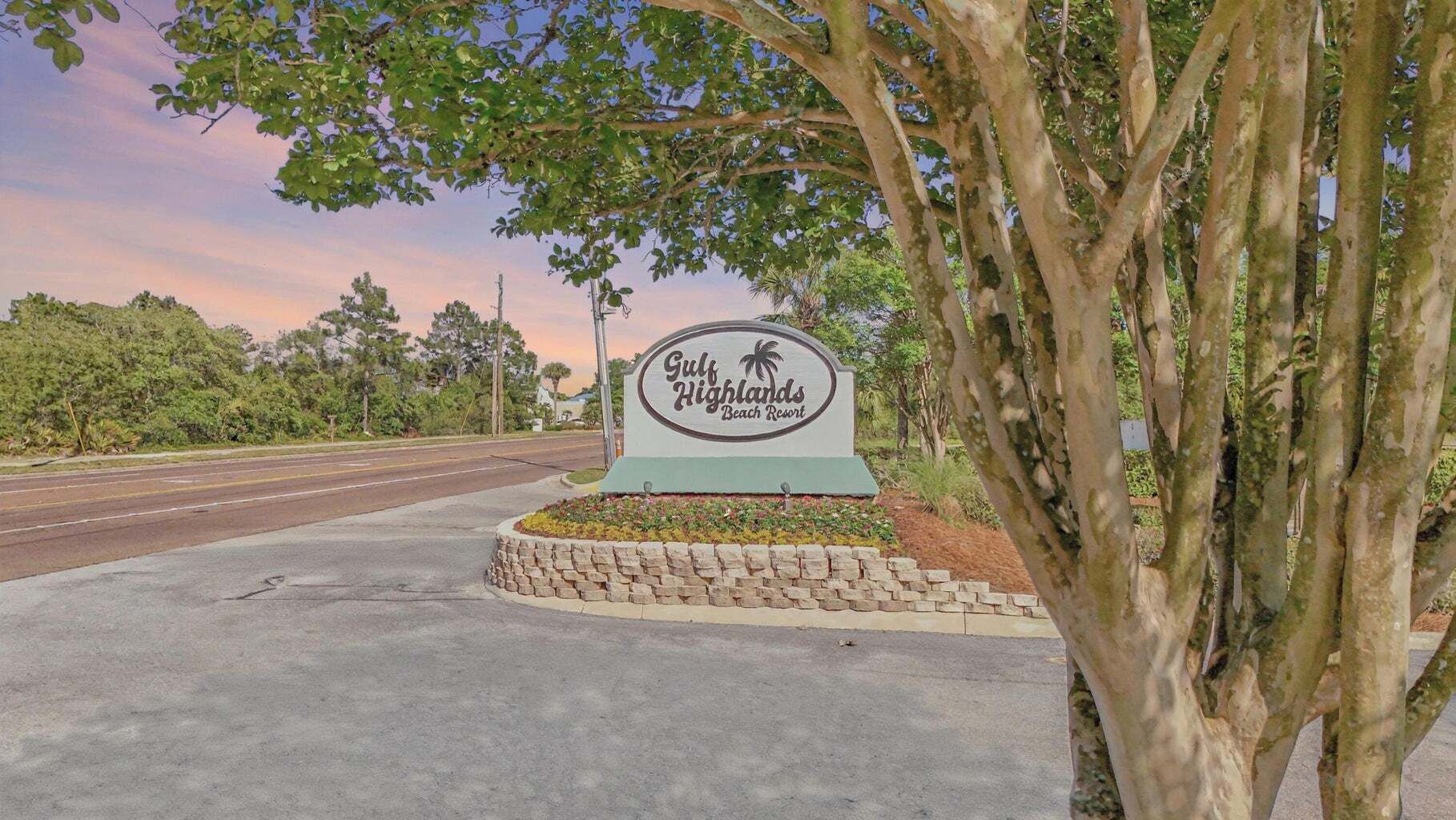 A sign for Gulf Highlands Beach Resort with a clear view of the surrounding landscape.