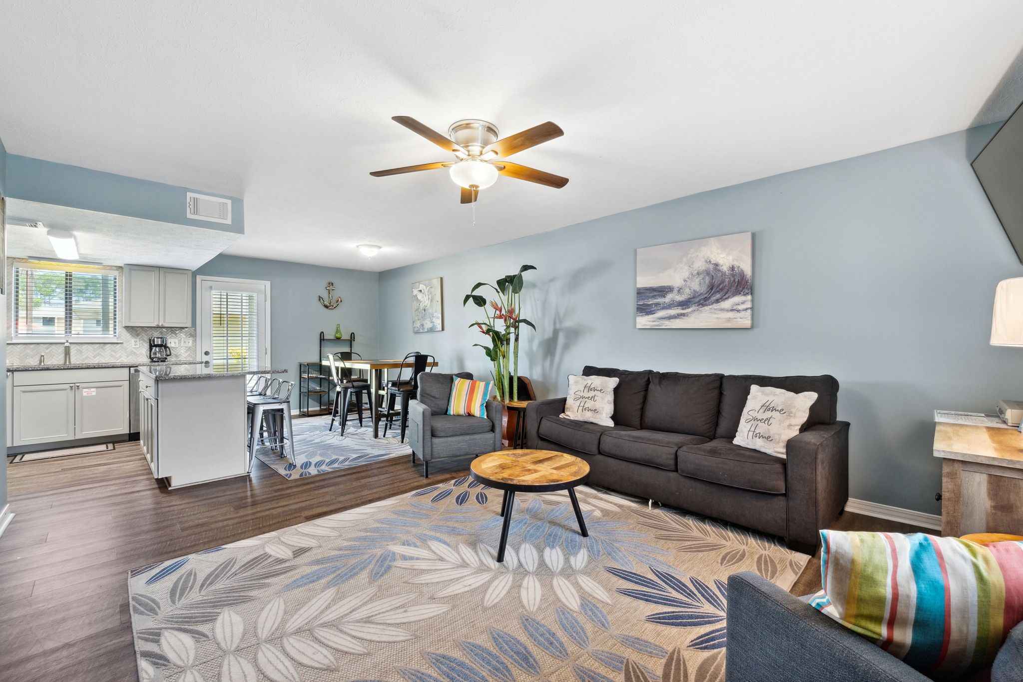 A modern living room with a sofa, coffee table, and a dining area with chairs.