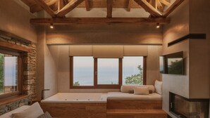 Een moderne woonkamer met een stenen muur, een groot raam, een open haard en een ingebouwde bank.