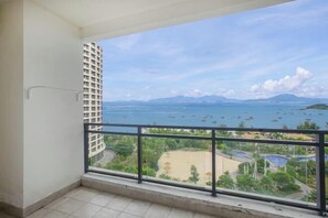 A balcony with a view of a beach and a body of water. - Yimi Yangguang Seaview Holiday Apartment (Huidong)