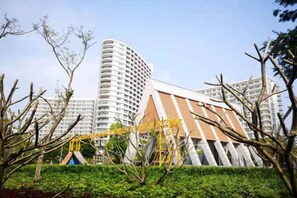 Un edificio moderno con un diseño arquitectónico distintivo, rodeado de vegetación y árboles.
