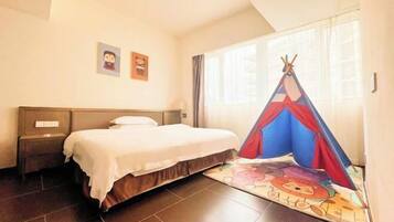 Habitación de hotel con cama, mesita de noche, ventana con cortinas y una decoración tipi colorida.