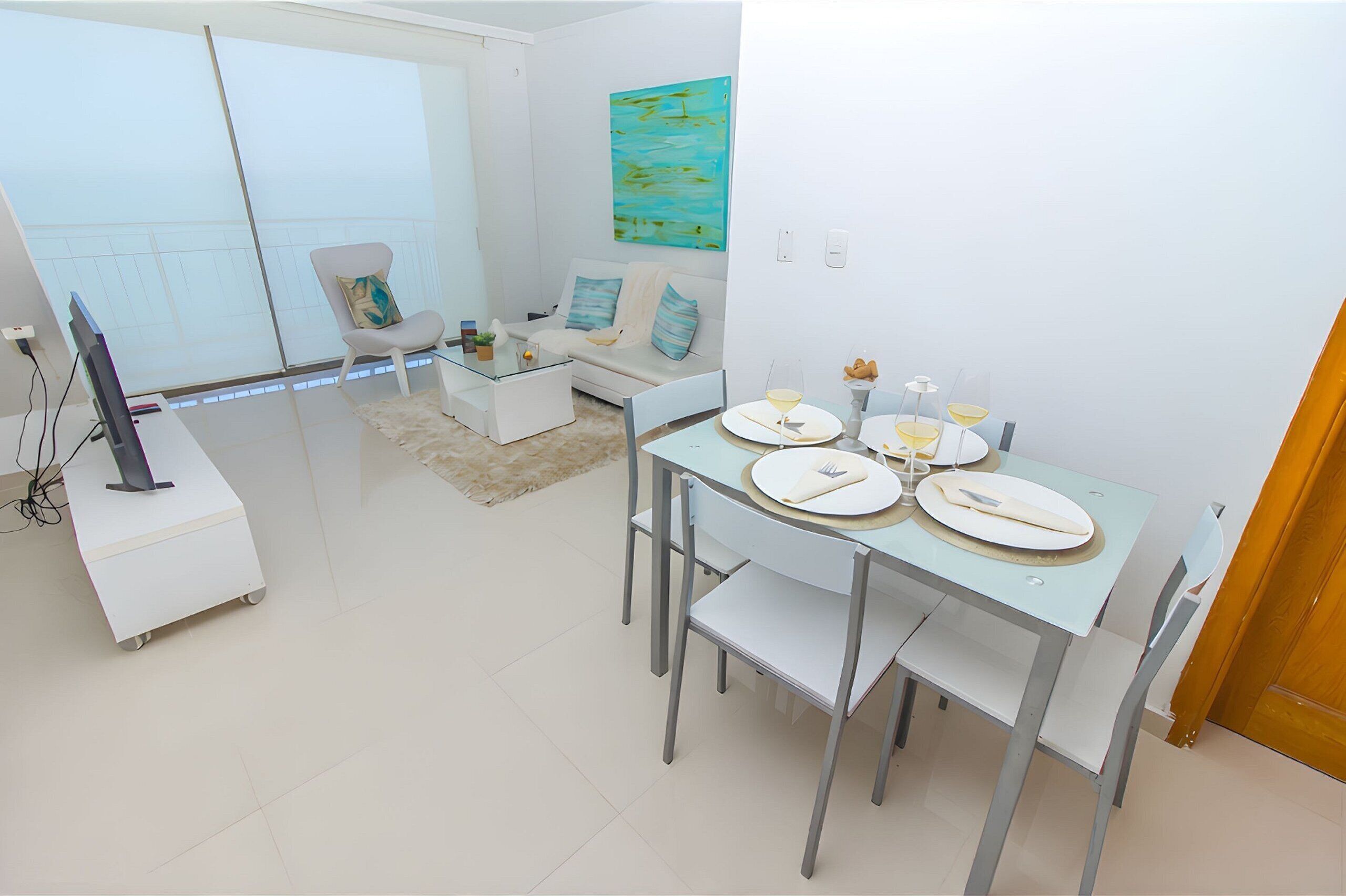 A modern living room with a dining area, a sofa, a coffee table, and a TV on a stand.