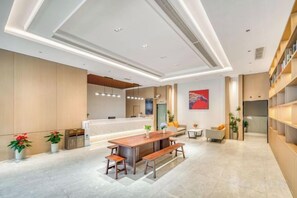 Un área de recepción moderna con un mostrador, asientos y una planta.