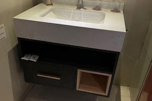 A bathroom with a sink, a towel rack, and a small cabinet. - Yueqing Yuecheng Donghai Holiday Hotel (Yueqing)