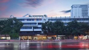 A modern hotel with a multi-story structure, a prominent entrance, and a reflection pool in front. - Qingyi Hotel (Taizhou)