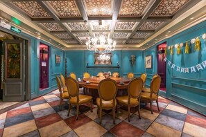A dining room with a round table, chairs, and a chandelier.