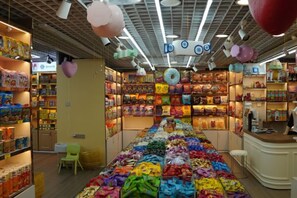 A candy store with shelves stocked with various sweets and a central display of colorful candies. - Xiyu International Hotel (Urumqi)