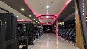 Un gimnasio con equipo de ejercicio y un espejo grande.