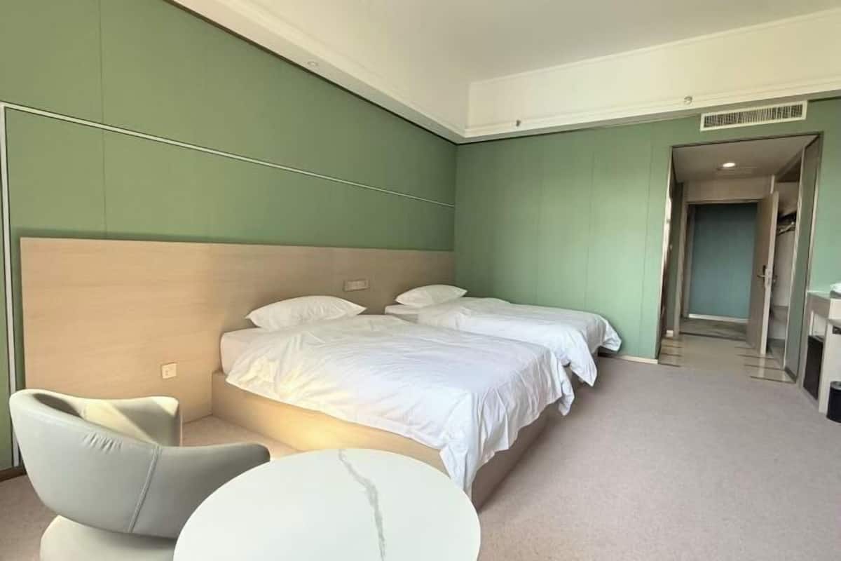 A hotel room with a bed, a chair, and a small table.