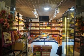 A grocery store with shelves stocked with various products, a refrigerated display case, and a checkout area. - Xiyu International Hotel (Urumqi)