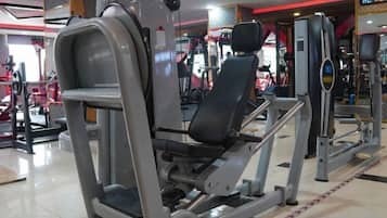 A gym with various exercise machines, including a leg press and a chest press.
