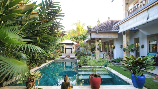 A pool surrounded by lush greenery and potted plants, with a statue and a small pavilion in the center. - Gorgeous, 3-bedroom Villa in the village of Penestanan/Ubud with AC, WiFi, Pool. (Bali)