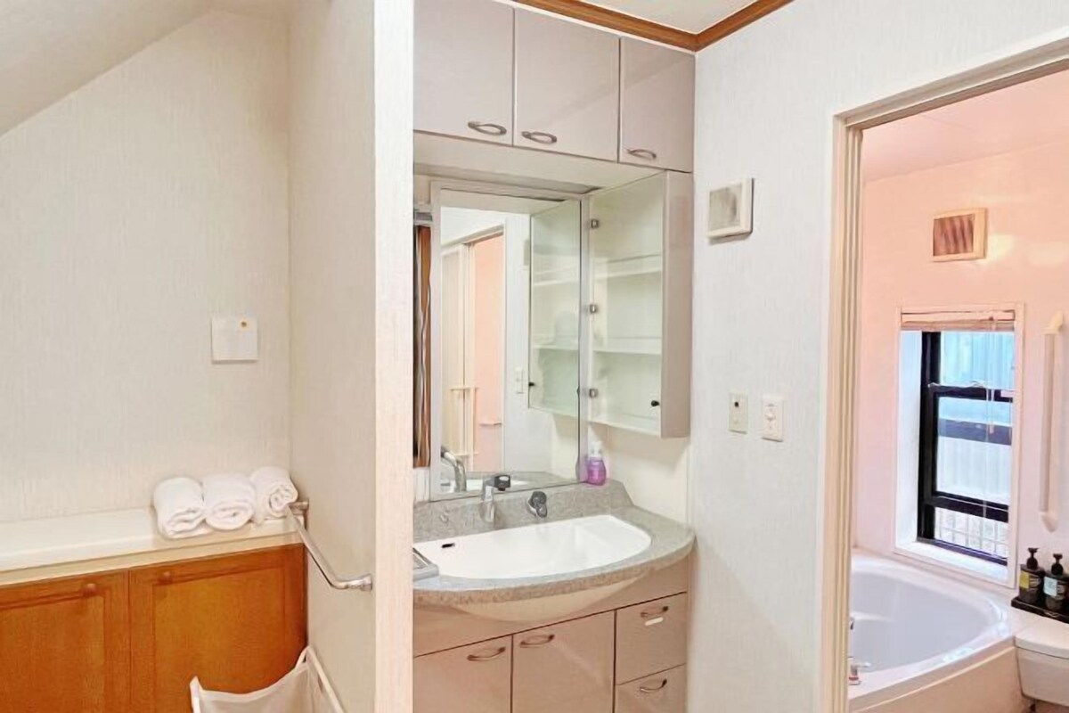 A bathroom with a sink, mirror, and bathtub.