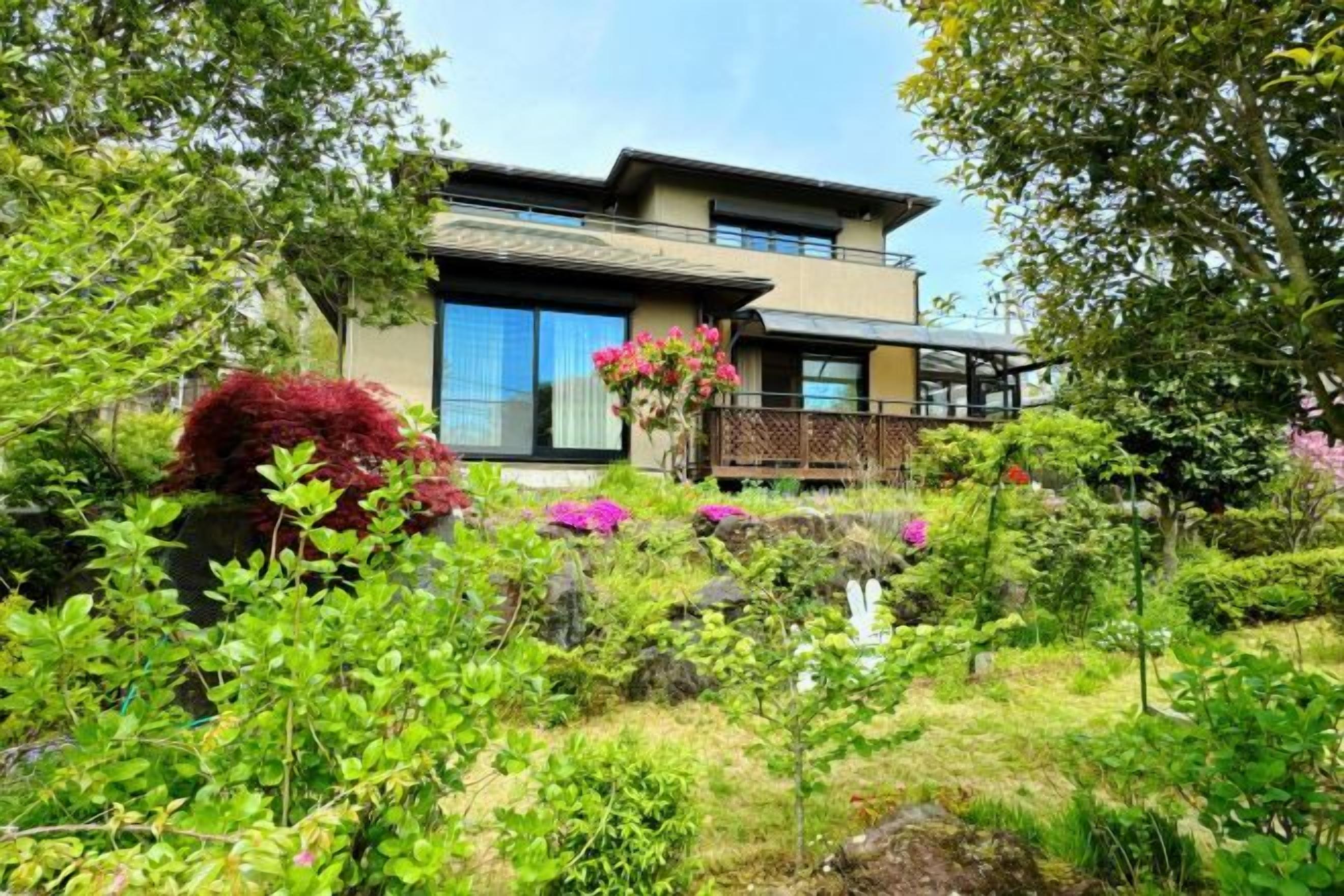 A two-story house with a garden in front.