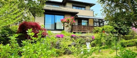 A two-story house with a garden in front.