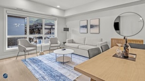 A modern living room with a sofa, chairs, a coffee table, and a dining table. - 2 Bed/2 Bath Sparrowhawk-Courtyard Facing-Sleeps 6 (Dead Man's Flats)