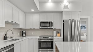 A modern kitchen with white cabinets, stainless steel appliances, and a large island. - 2 Bed/2 Bath Sparrowhawk-Courtyard Facing-Sleeps 6 (Dead Man's Flats)