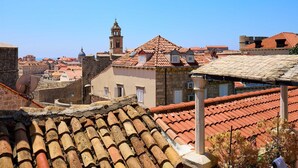 A historic town with terracotta-tiled rooftops, stone buildings, and a prominent bell tower. - Karma Suites by Dominium Comfort double room (Dubrovnik)