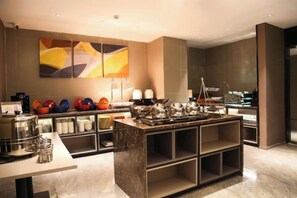 A modern kitchen with a marble island, built-in appliances, and a large abstract painting on the wall. - Homeinn Selected Hotel (Beijing Normal University Jishuitan Subway Station) (Beijing)