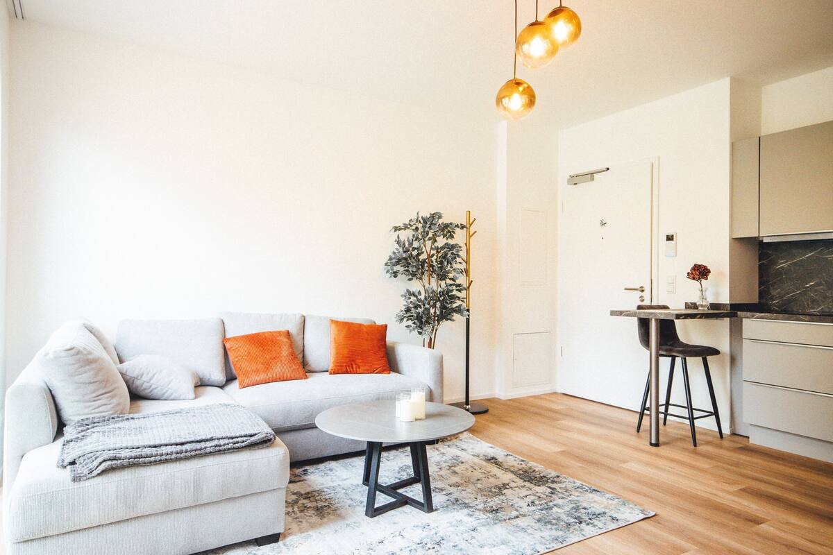 Un salon moderne comprenant un canapé, une table basse et un coin repas avec une chaise et une table.