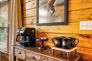 A wooden coffee station with a coffee maker, a tray with mugs, and a framed picture on the wall. - Mountain Views+Hot Tub+Fire Pit+4 Mi to Pigeon Forge (Sevierville)