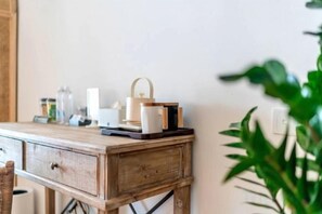 A wooden desk with a lamp, a candle, and a plant.