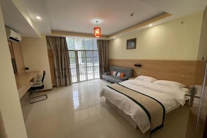 Quarto de hotel com cama, sofá, escrivaninha e cadeira.