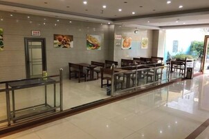 Un restaurante moderno y limpio, con una larga barra y varias mesas.
