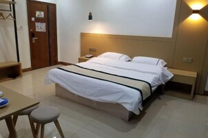 Una habitación de hotel con cama, mesitas de noche, escritorio y una silla.