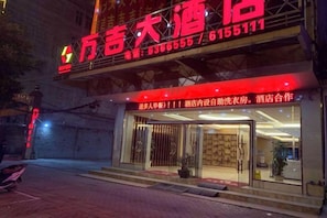 A hotel with a prominent red sign and a well-lit entrance. - Jingxi Wanji Hotel (Jingxi)