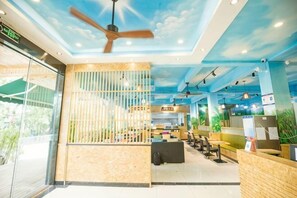 A hotel lobby with a ceiling fan, a reception desk, and a seating area. - Nongzai Guesthouse (Sanya Wuzhizhou Island Houhai) (Sanya)