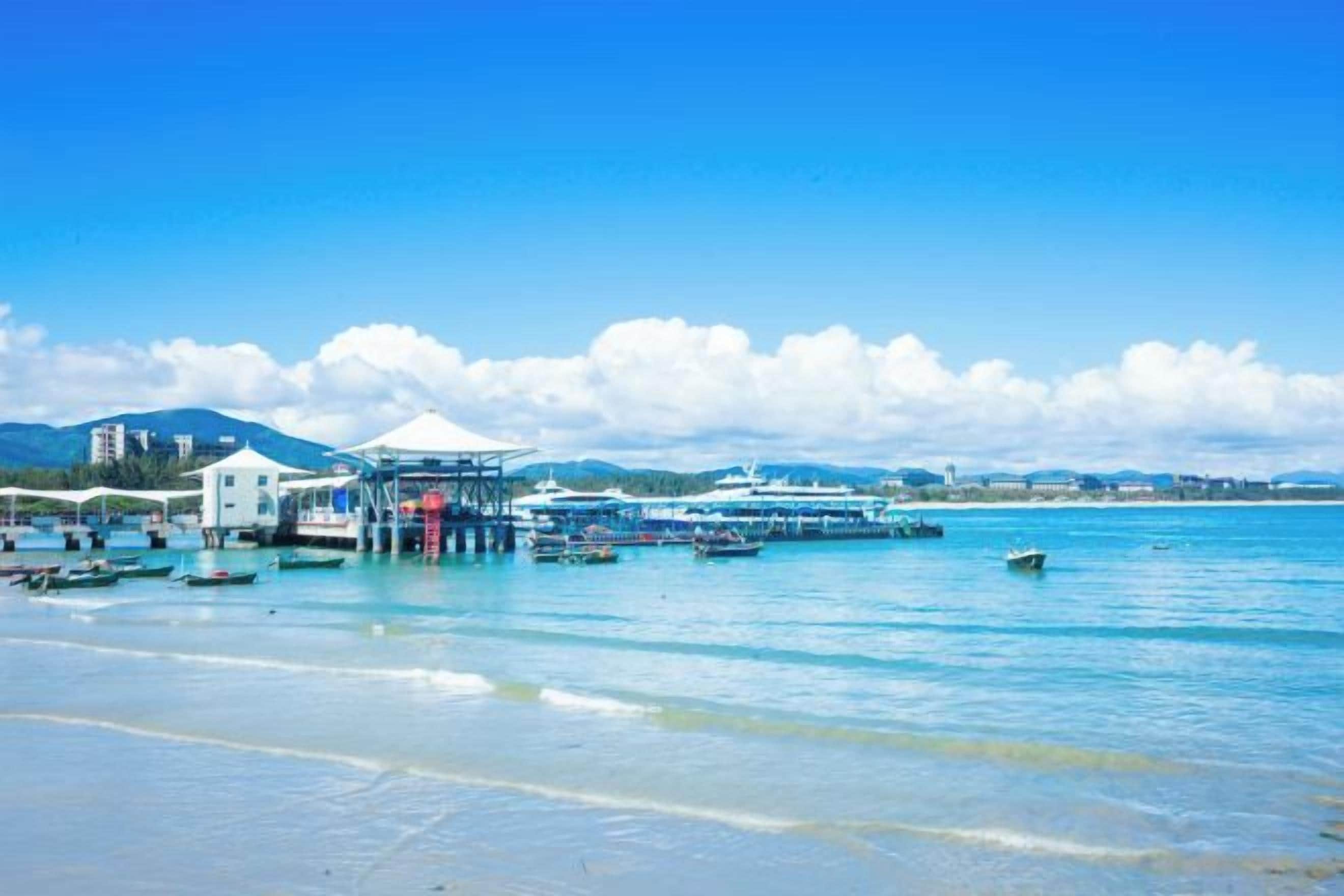 A coastal area with a pier, boats, and a clear sky.