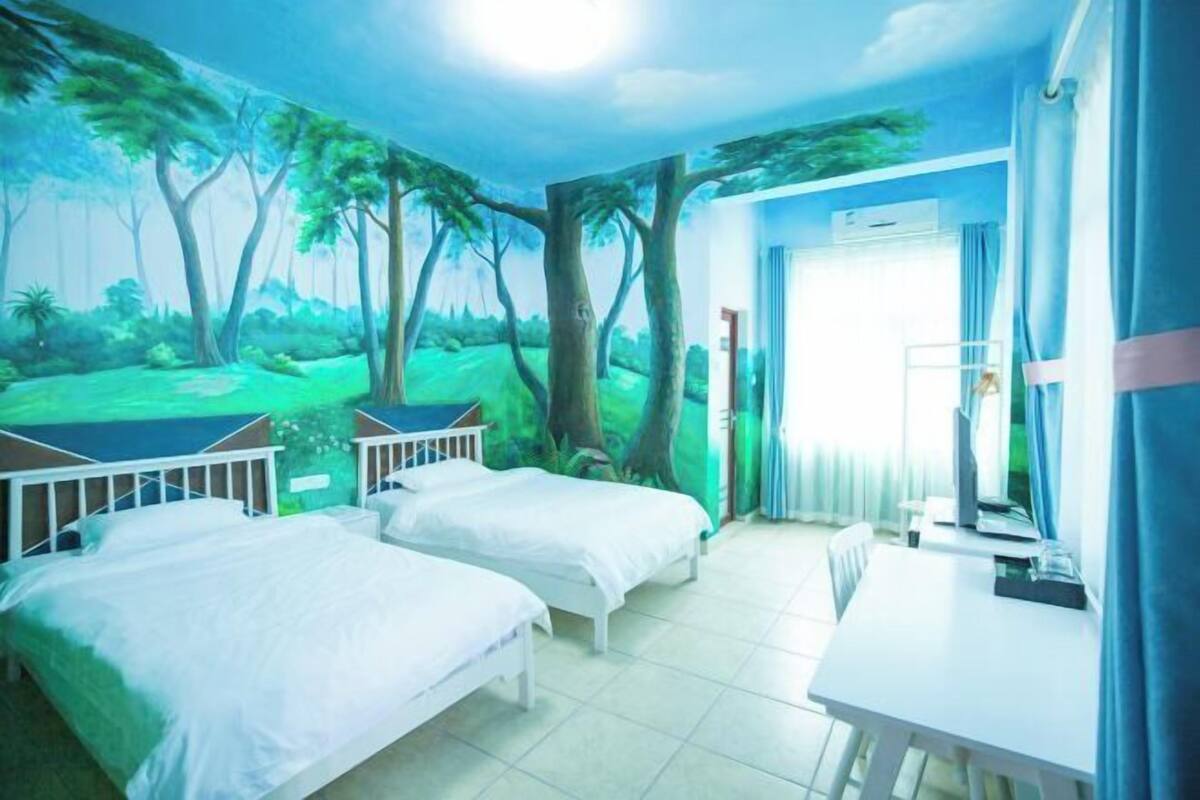 Une chambre avec deux lits, un bureau et une fresque représentant une scène de forêt.