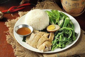 A plate with rice, sliced chicken, a boiled egg, and green vegetables. - Nongzai Guesthouse (Sanya Wuzhizhou Island Houhai) (Sanya)