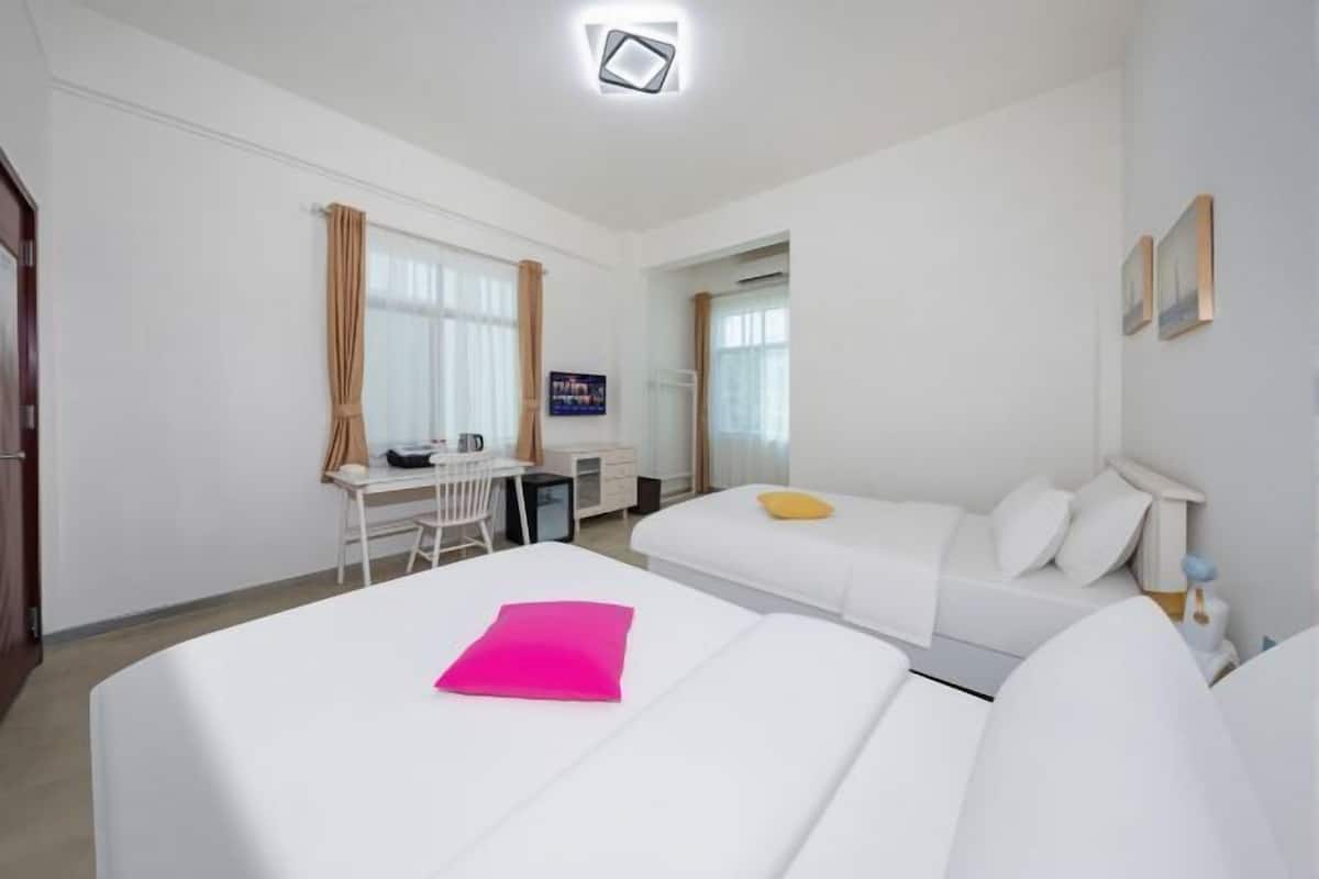 Une chambre d’hôtel avec deux lits, un bureau et une chaise.