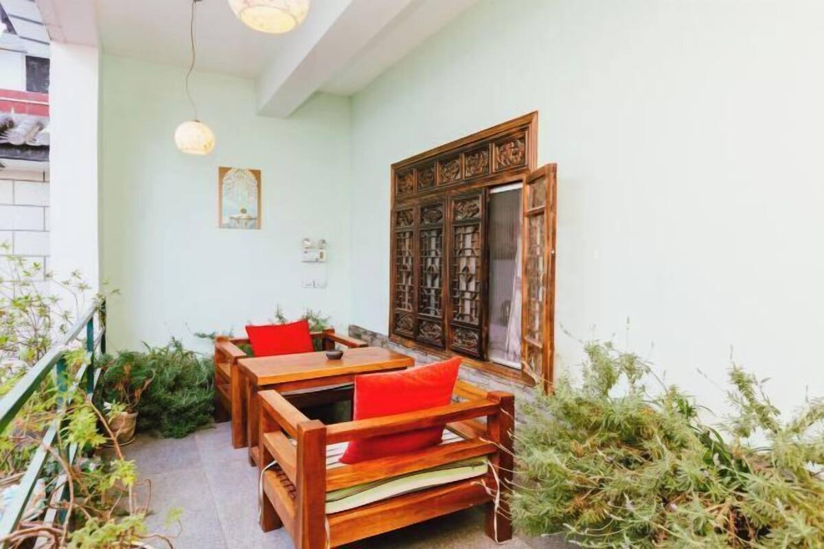 A traditional room with wooden furniture, a decorative wooden door, and potted plants.