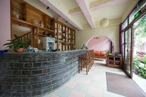 A kitchen with a stone counter, wooden cabinets, and a dining area with a bench and chairs. - Dali Ancient City Xiaoqiang Craft Theme Homestay (Dali City)