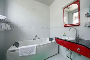 A bathroom with a bathtub, a sink, a mirror, and a towel rack. - Dali Ancient City Xiaoqiang Craft Theme Homestay (Dali City)