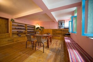 A room with wooden flooring, a dining table with chairs, a bench, and a wall-mounted shoe rack. - Dali Ancient City Xiaoqiang Craft Theme Homestay (Dali City)