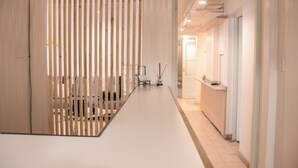 A modern interior with a long, narrow reception desk and a wooden slat partition. - Exclusiva Casa en una de las Mejores Zonas de Mendoza (Buenos Aires)