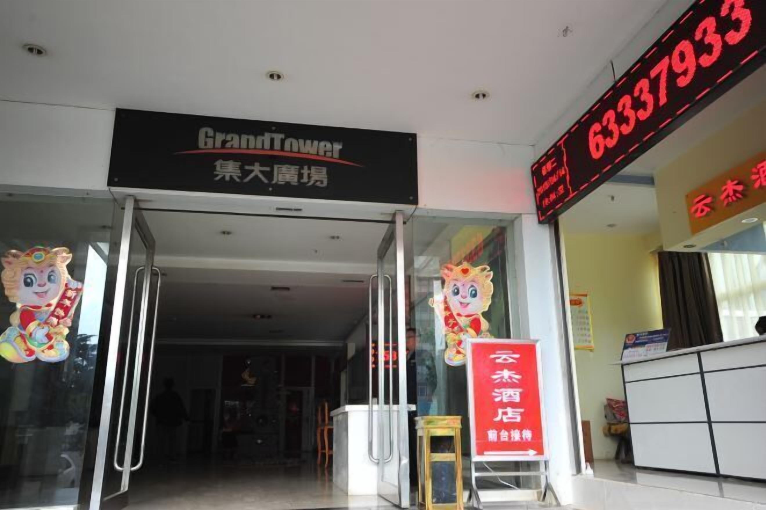 The entrance to a hotel with a digital sign displaying the number 63337933.