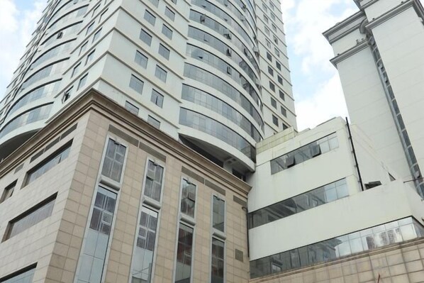 A tall, curved building with multiple floors and large windows.