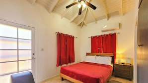 A bedroom with a bed, a nightstand, a lamp, a ceiling fan, and a window with curtains. - Cozy 1-bedroom apartment in peaceful Valley with AC, WiFi (Cassada Gardens)