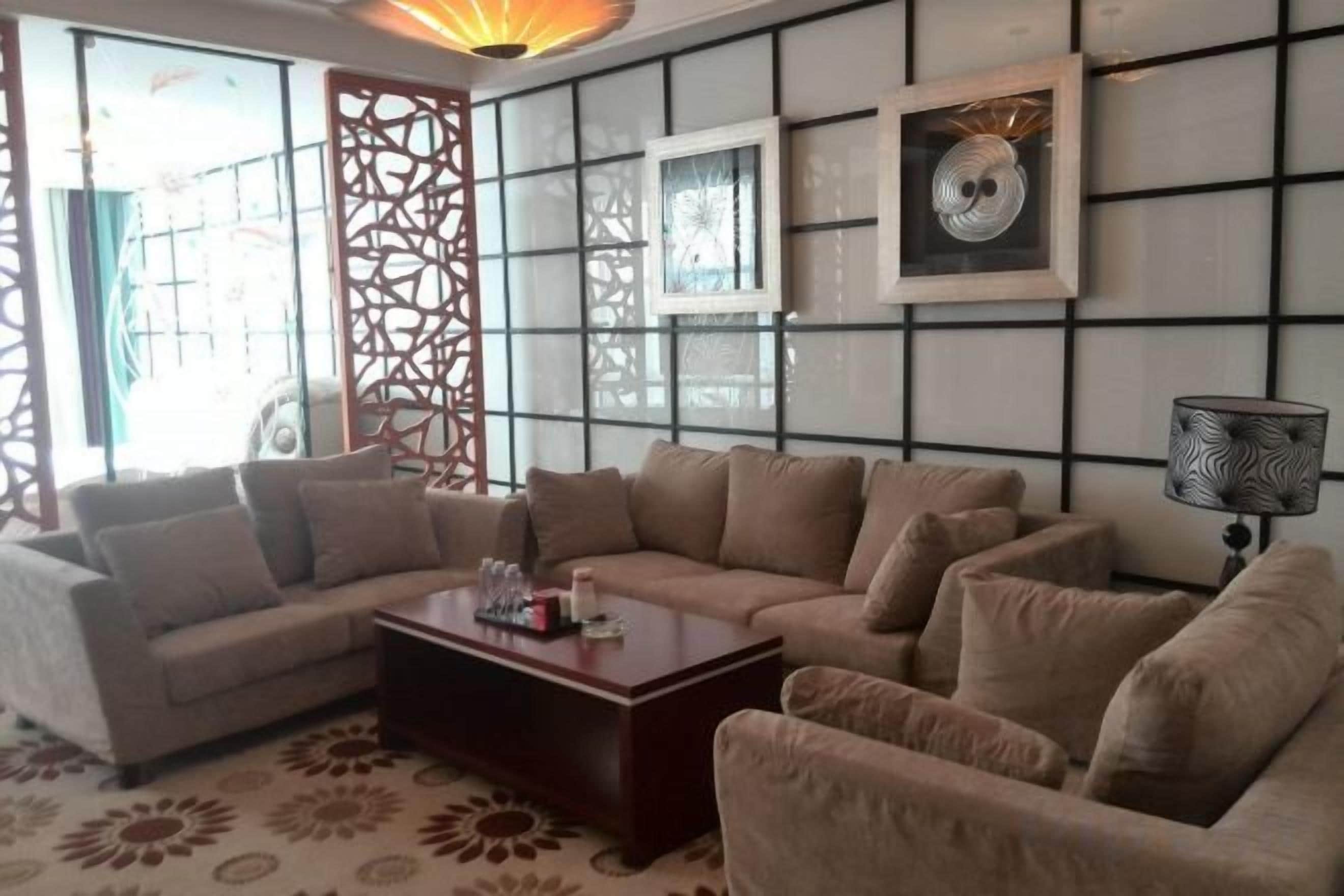 A living room with a sectional sofa, a coffee table, and a TV mounted on the wall.