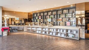 A modern interior with a central counter, shelves with items, and a wooden floor. - Beau Upward Maylily Hotel (Yinchuan)