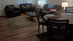 A living room with a dining table, chairs, a sofa, and a ceiling fan. - Recently updated cottage minutes from beach, pet friendly, large yard wifi, ac (Longs)